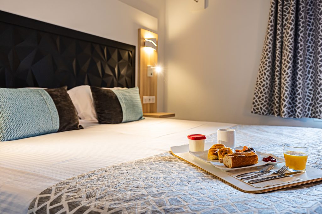 Comfortable room with double bed and river view at the best western hotel le moulin de ducey in normandy